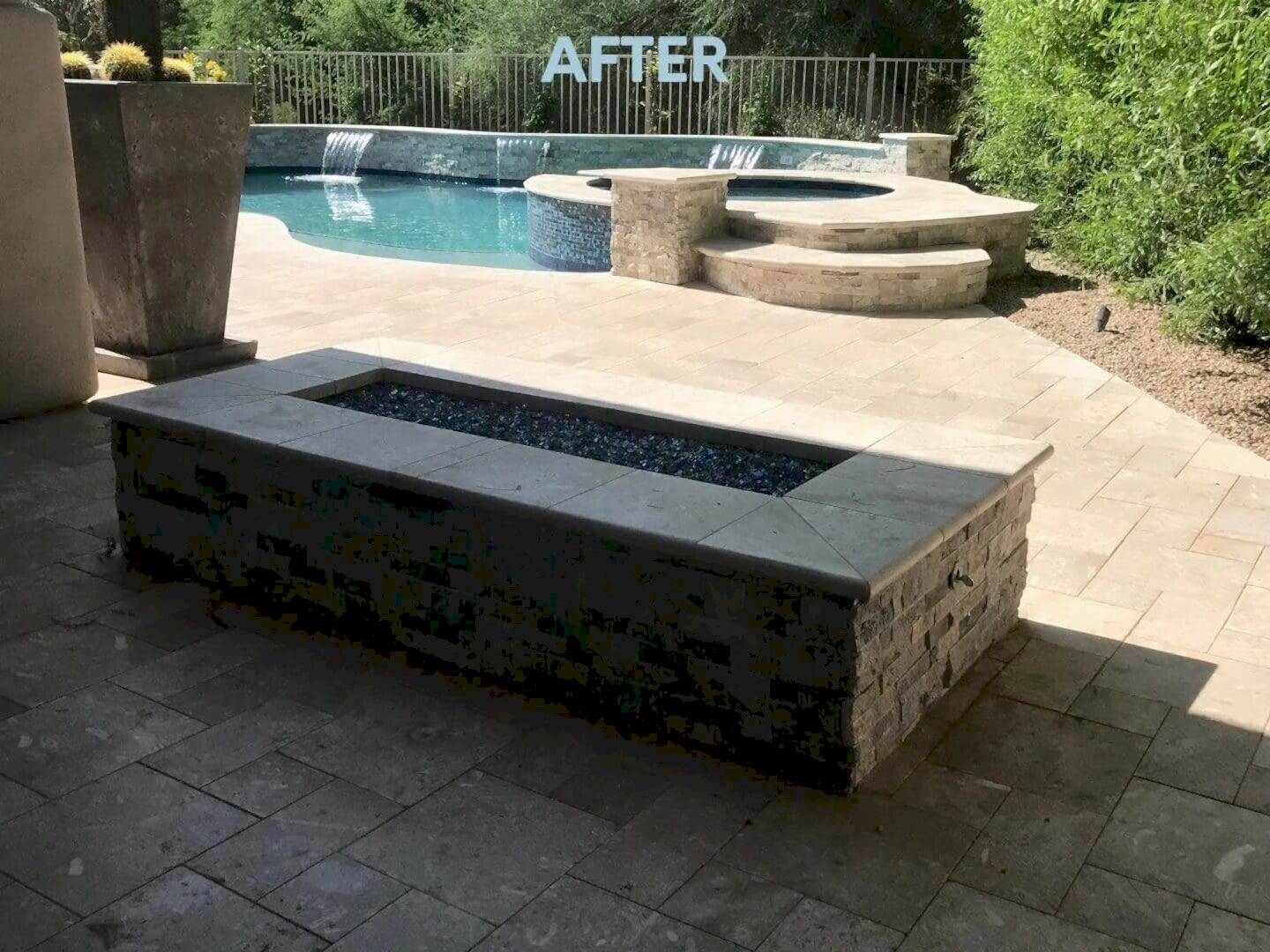 A fire pit sitting next to the side of a pool.