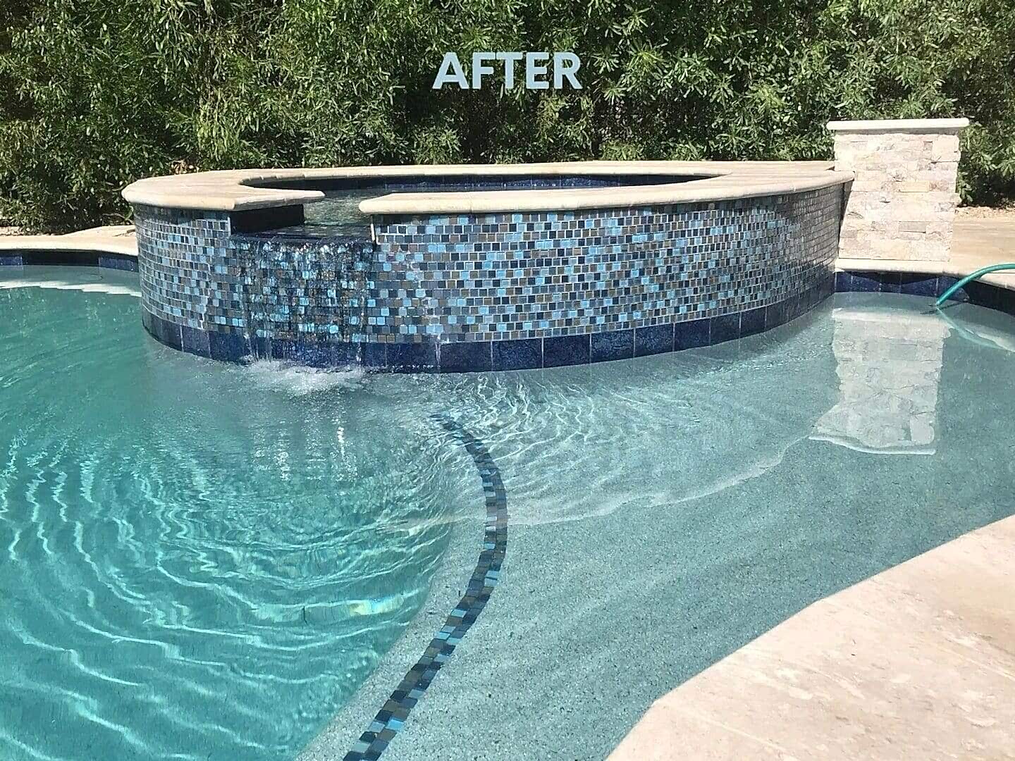 A pool with a blue tile surround and a black tile trim.