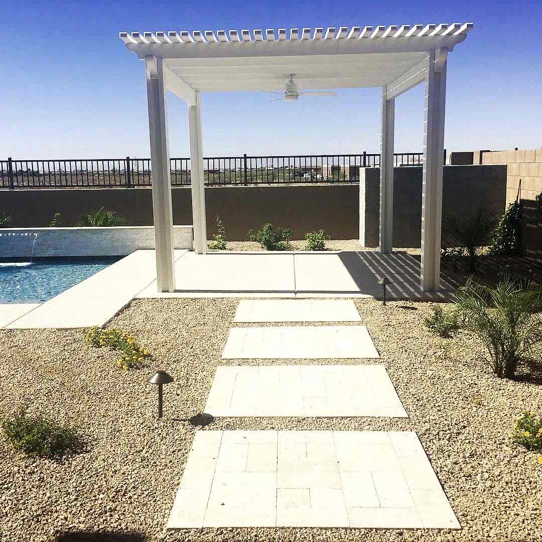 A white pergola near the pool with a walkway.