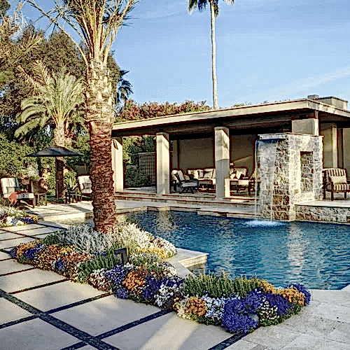 A pool with a palm tree and a fountain.