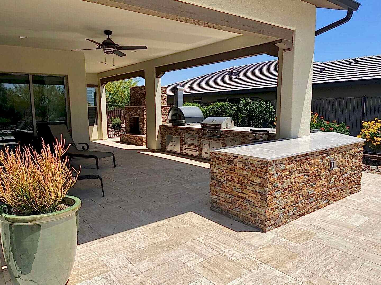 Outdoor kitchen with pizza oven and seating.