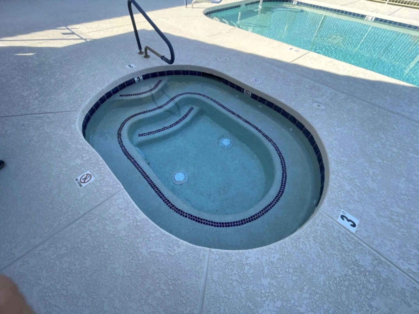 Here's an alt tag for the image: Small pool spa with steps.