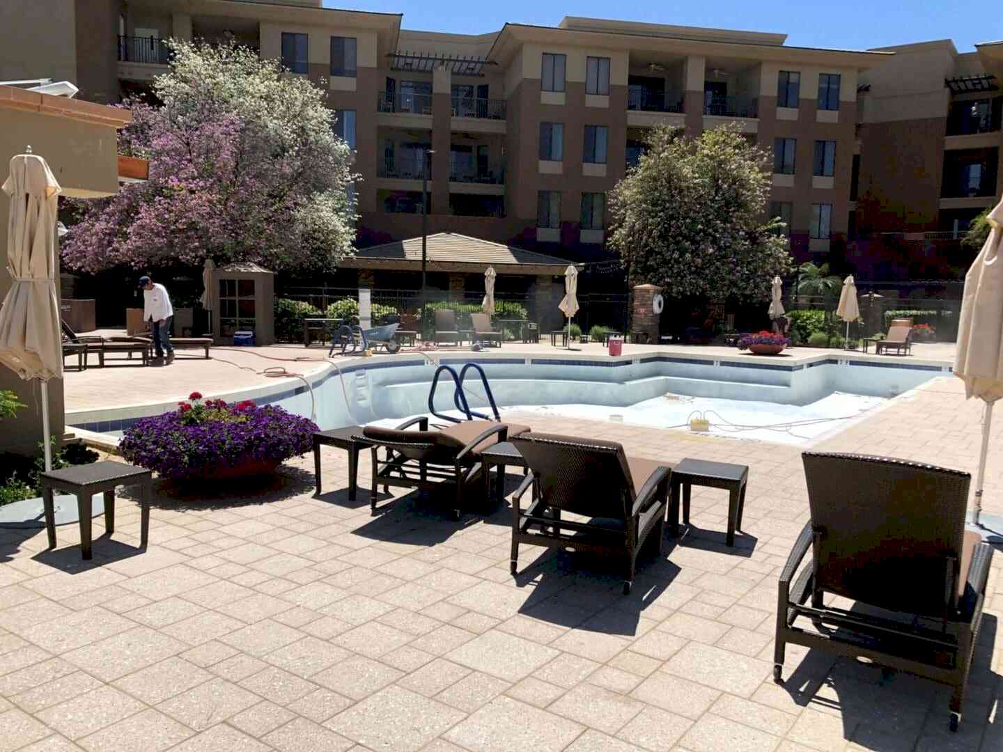 Empty pool under renovation near building.