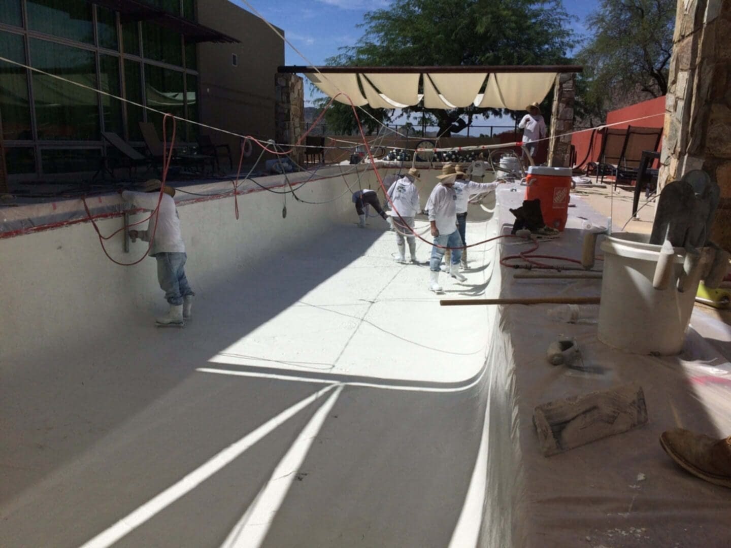 Workers plastering a swimming pool.