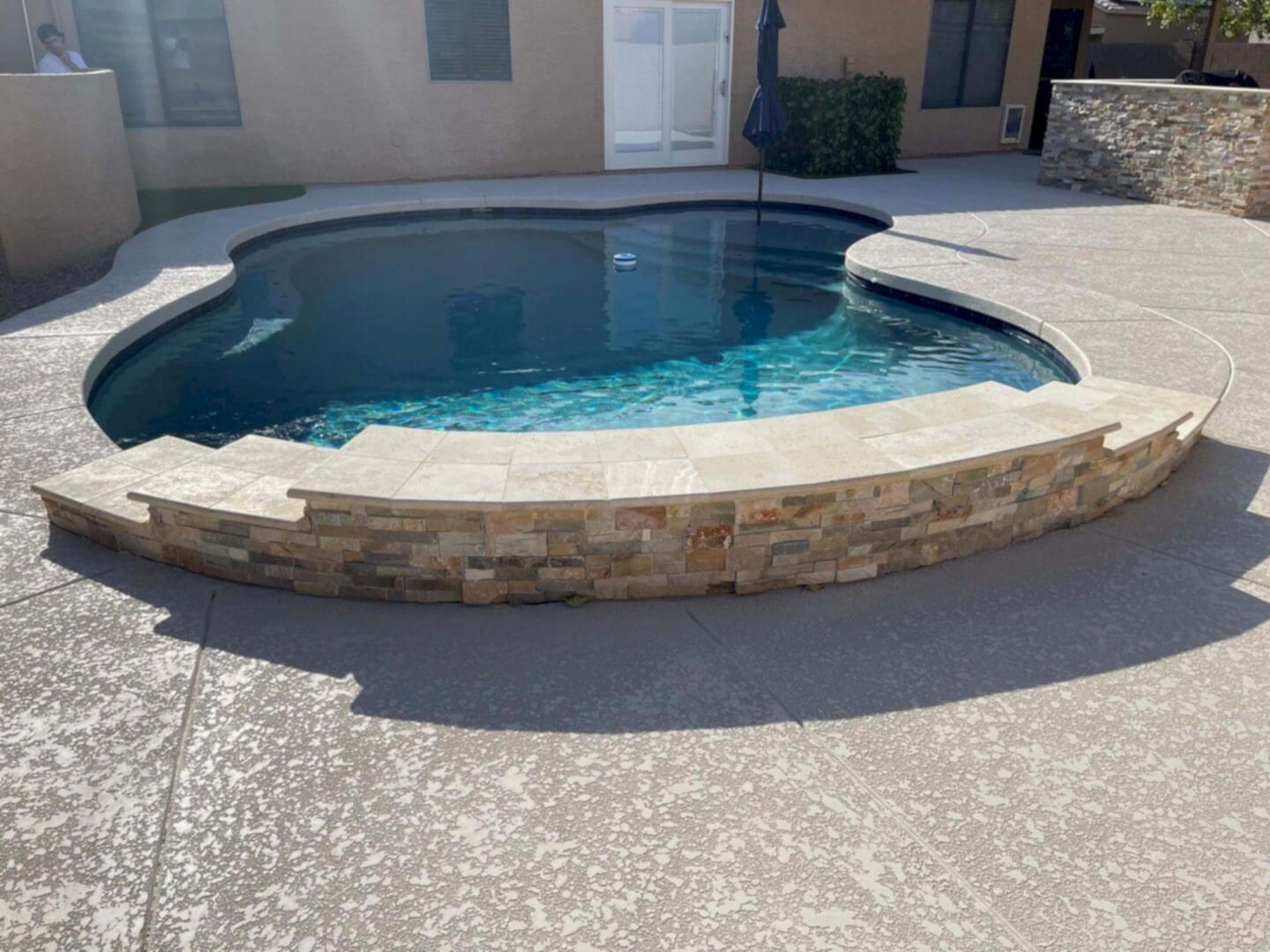 Freeform pool with stone coping.