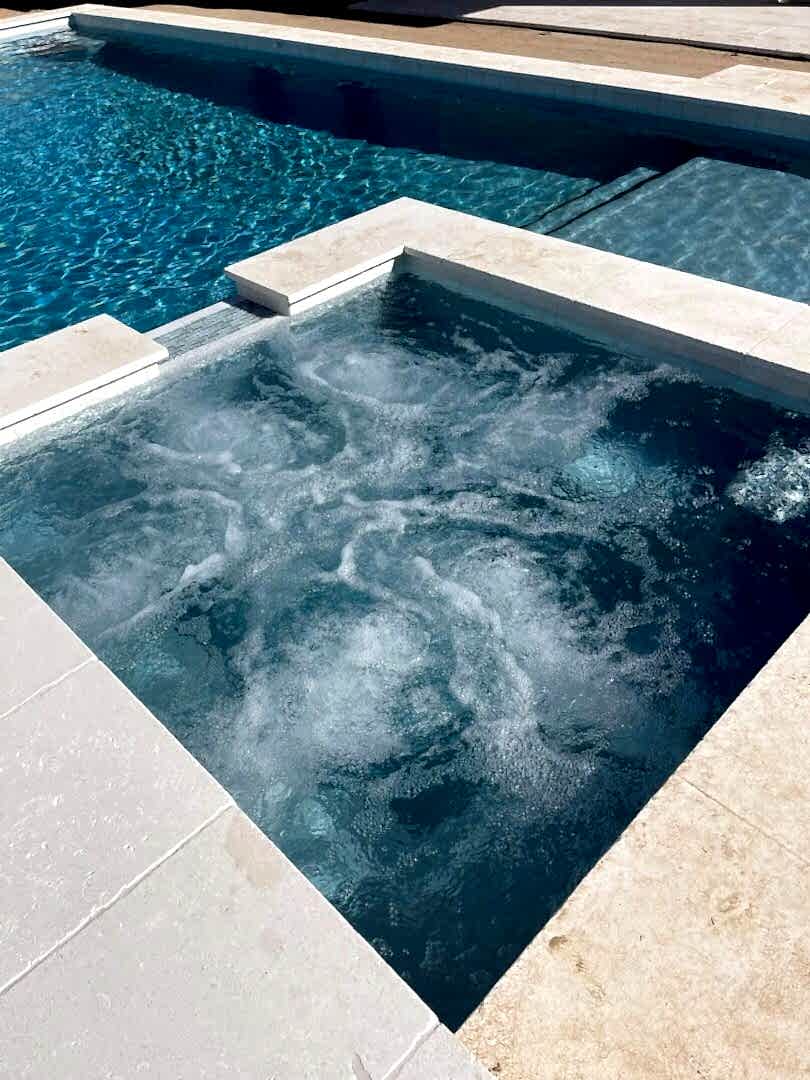 Here's an alt tag for the image: Bubbling spa and swimming pool.