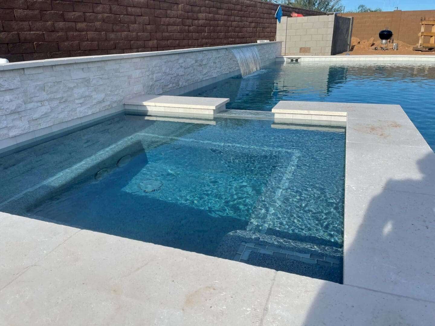 Spa and pool with waterfall feature.