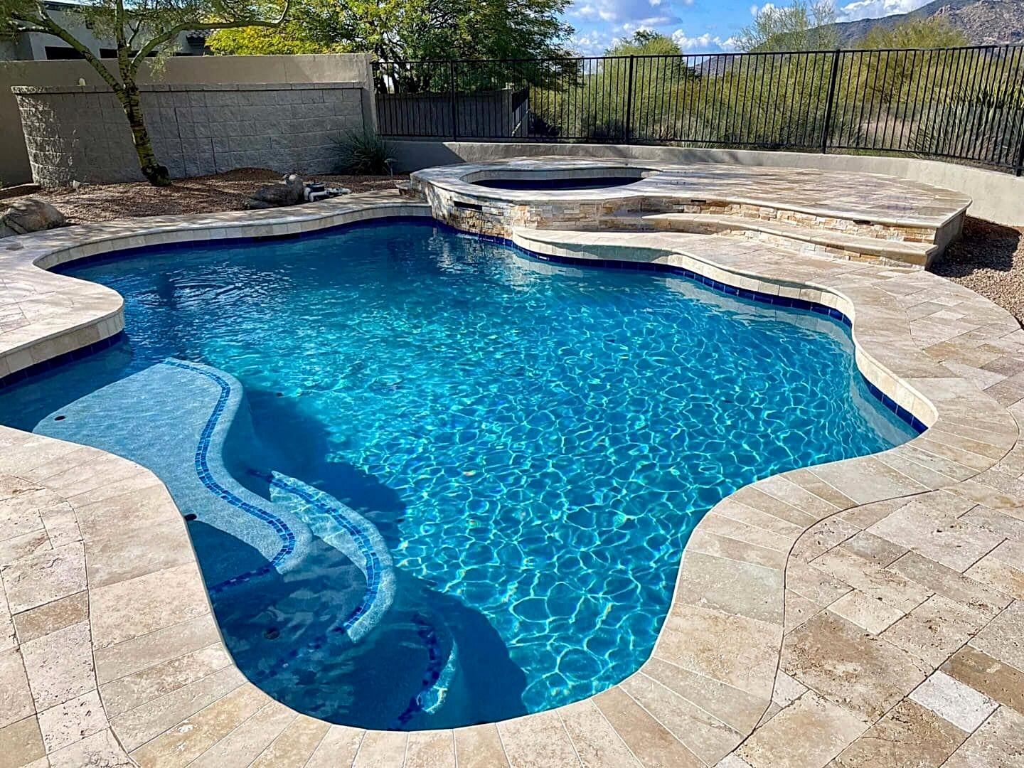 Stunning blue pool with spa and tan tile.