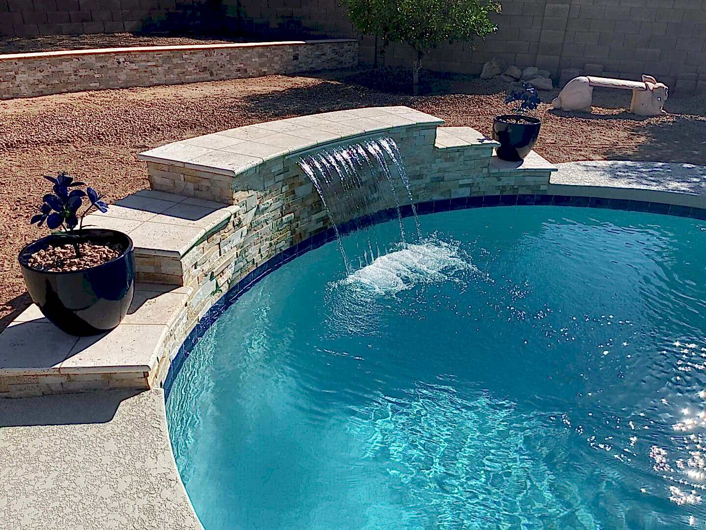 Stone waterfall cascading into pool.