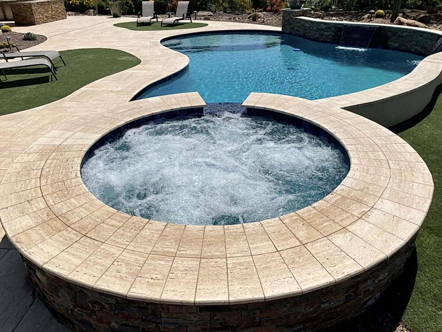 Here's an alt tag for the image: Bubbling spa and curved pool.