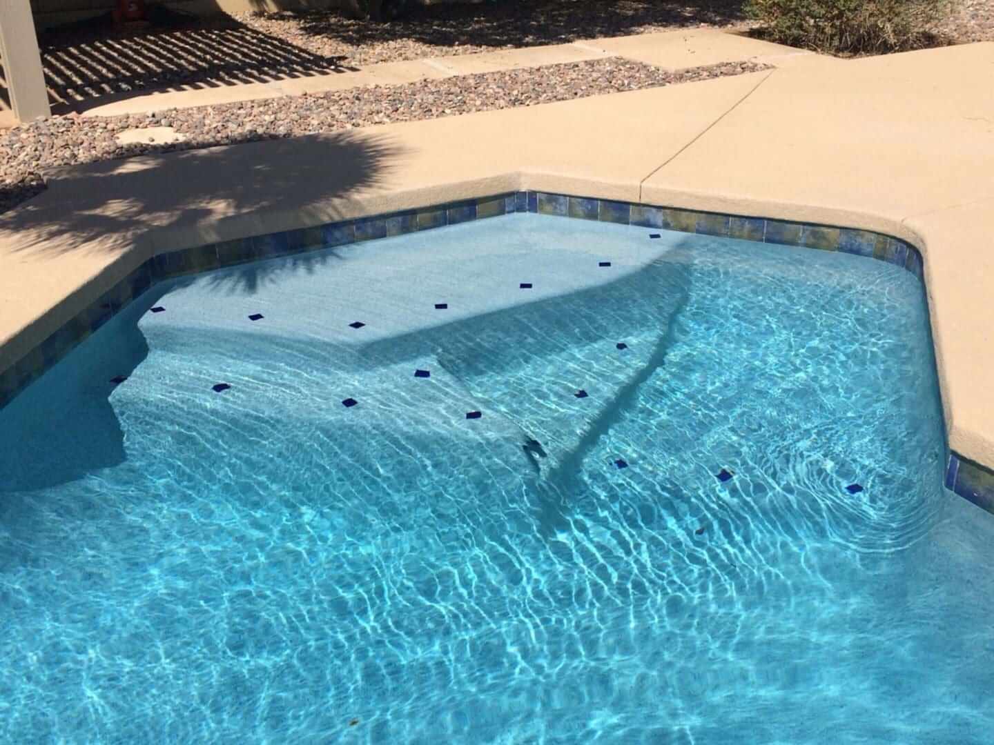 Here's a suitable alt tag: Blue swimming pool with tile accents.