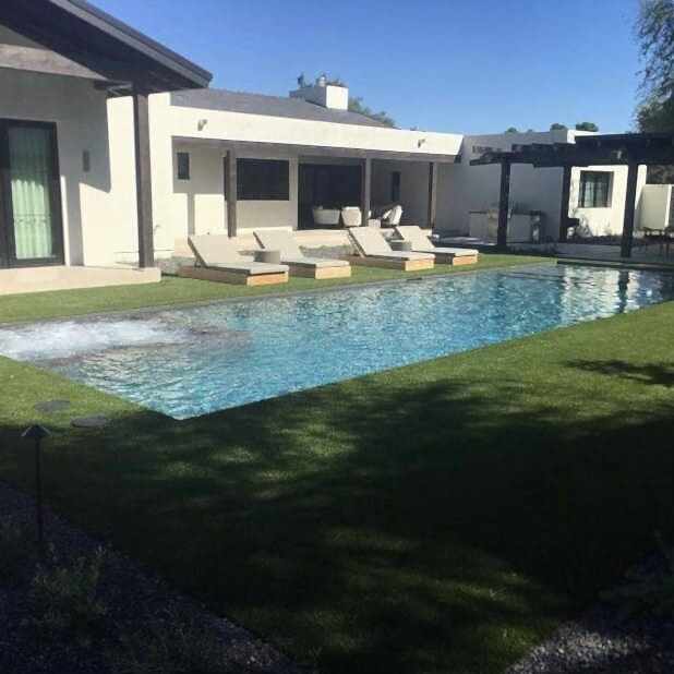 Modern house with pool and loungers.