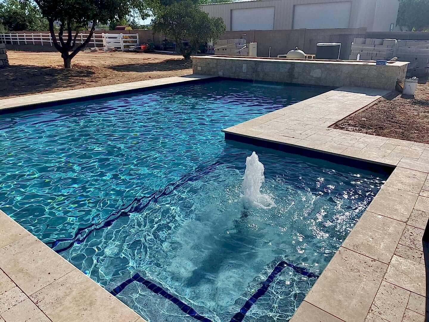 Here's an alt tag for the image: Swimming pool with water feature.