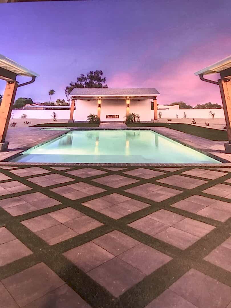 Modern backyard pool and patio at dusk.