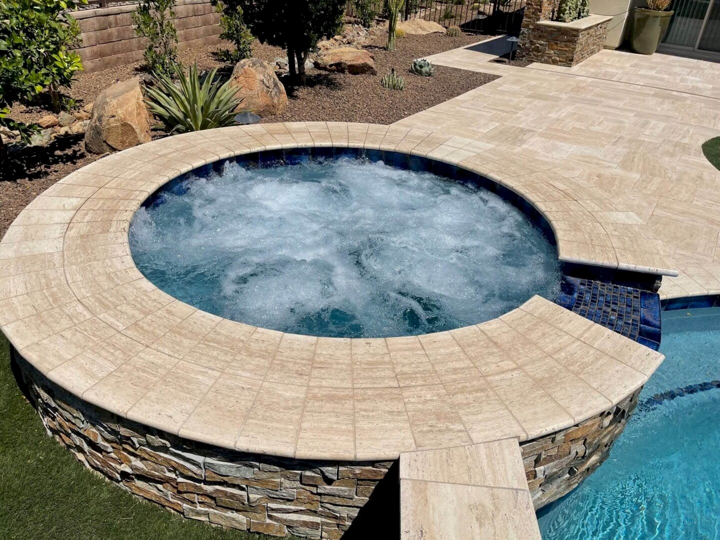 Luxury spa bubbling in backyard pool.