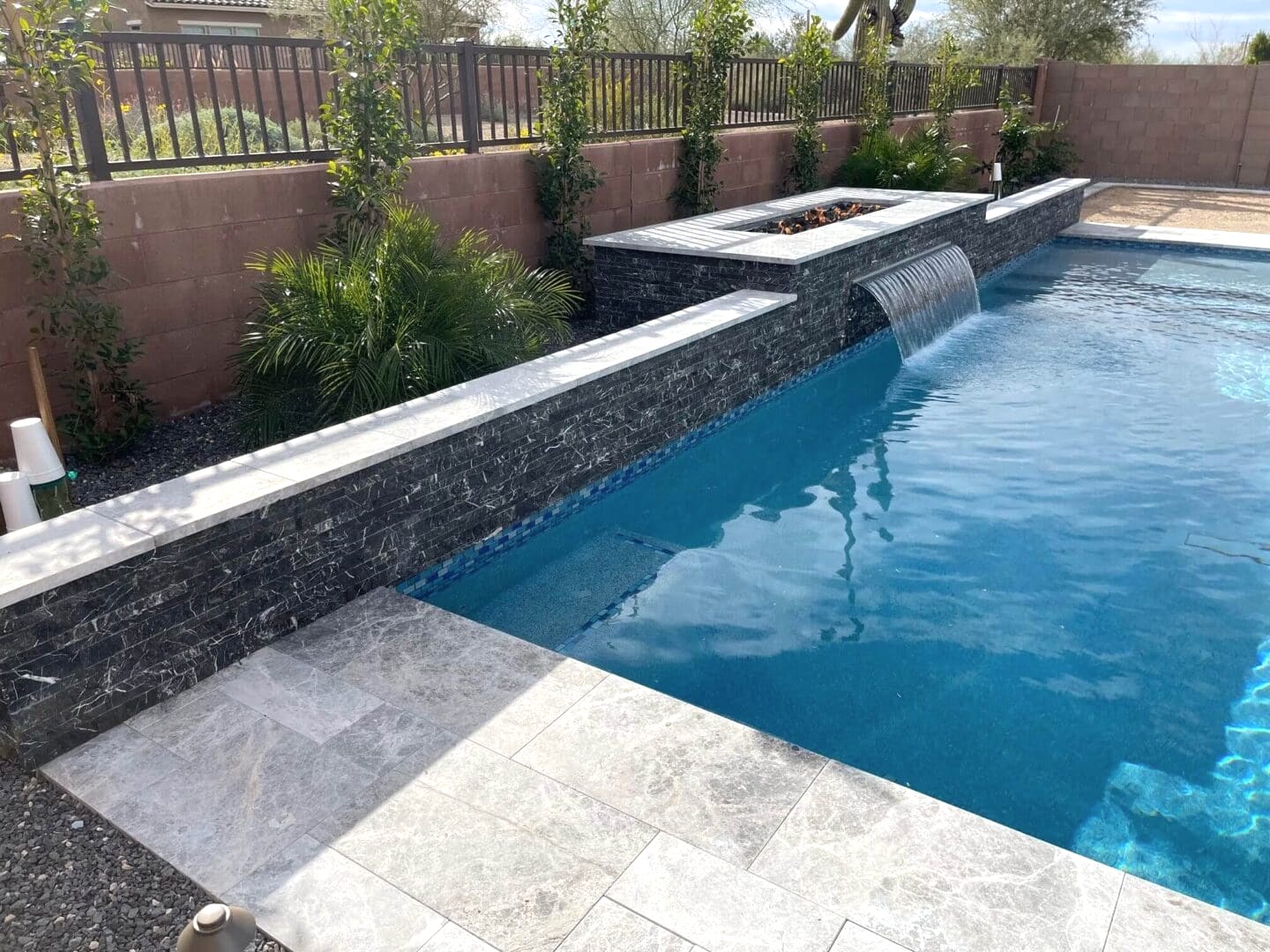 Modern pool with waterfall feature.