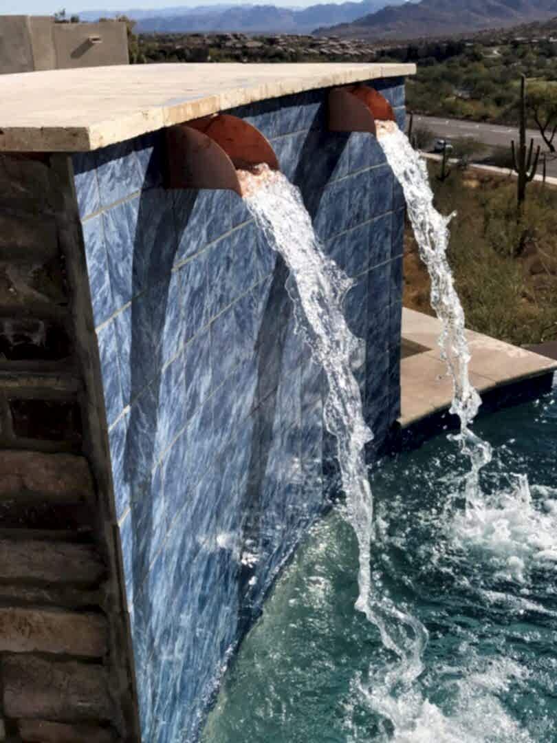 Copper spouts cascading into pool.